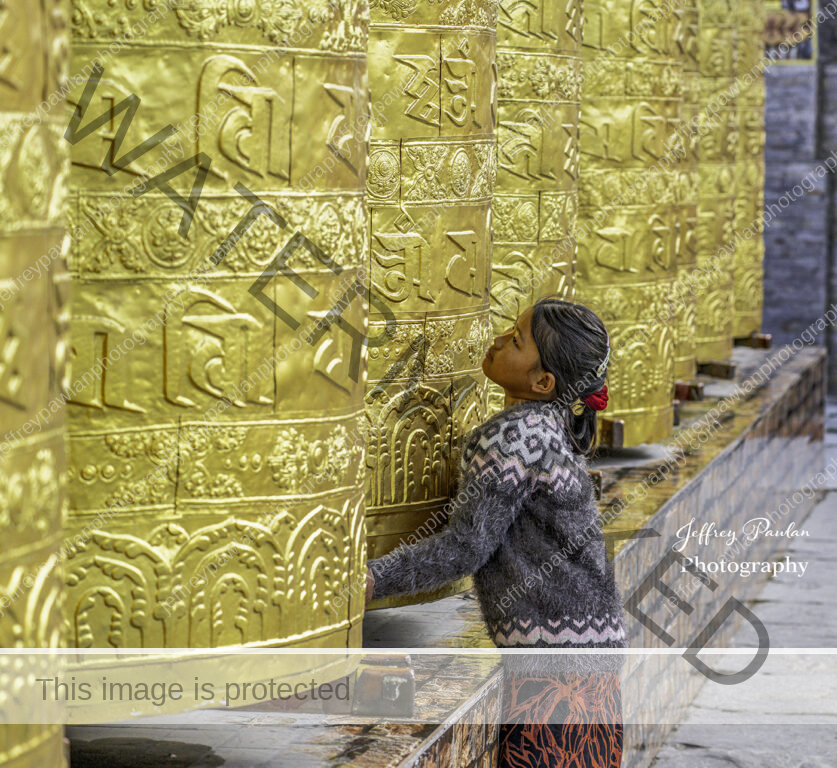 920575-Bhutan-girl-turning-the-prayer-wheels-signed-WP-1-837x768